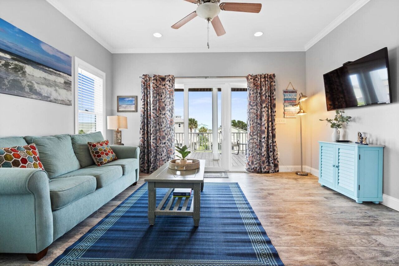A living room with a sofa, coffee table, and a ceiling fan.
