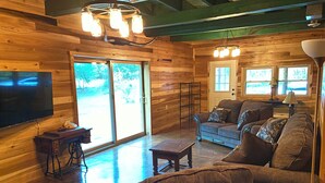 Ein gemütliches Holzinterieur mit einer Couch, einem Fernseher und einem Tisch.