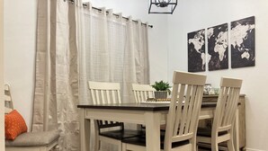 A dining area with a table and chairs, a potted plant, and a world map on the wall.