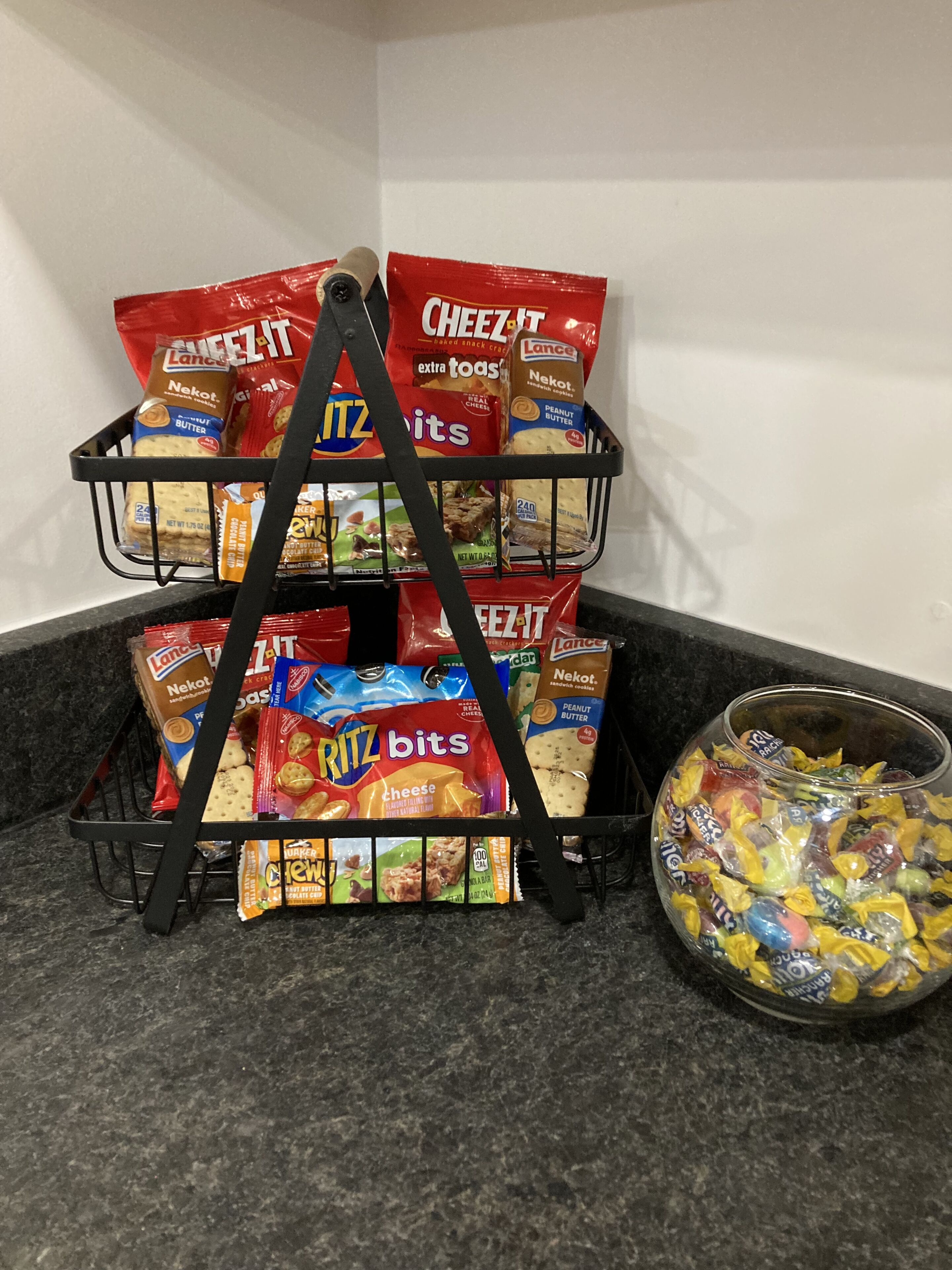 A snack rack with various packaged snacks and a bowl of candies.
