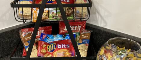 A snack rack with various packaged snacks and a bowl of candies.