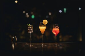 Three glasses of different colored beverages on a dark surface with a blurred background. - JIJIJIN Mastsuyama (Tobe)