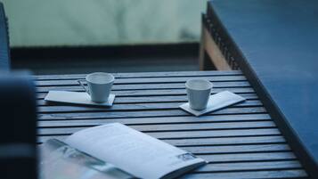 Una mesa de madera con dos tazas blancas y un libro.