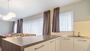 Eine moderne Küche mit weißen Schränken, einer Holz Arbeitsplatte und einer eingebauten Spüle.