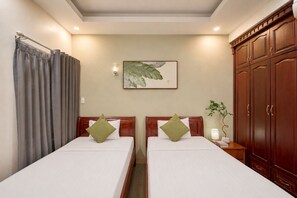 A hotel room with two beds, a large wooden wardrobe, a wall-mounted plant, and a framed artwork. - Cactusland Hotel Tan Binh (Ho Chi Minh City)