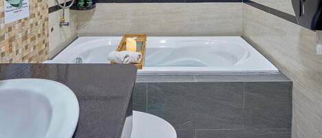 A modern bathroom with a bathtub, a toilet, and a sink.