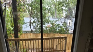 A room with a wooden deck, a glass door leading outside, and a light-colored wooden floor. - Tranquil 2-bedroom condo in Augusta with AC, WiFi (Augusta)