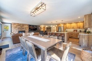 Une cuisine moderne avec des meubles en bois, un four encastré et un réfrigérateur en acier inoxydable.
