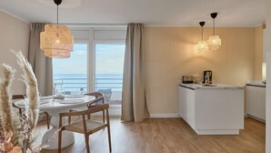 Una cocina moderna con comedor, vistas al mar y un balcón.
