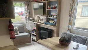 A compact living space with a kitchenette, a dining area, and a small seating area.