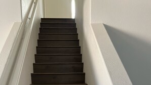 Eine Treppe mit dunklen Stufen, die zu einer Zwischenebene führen.
