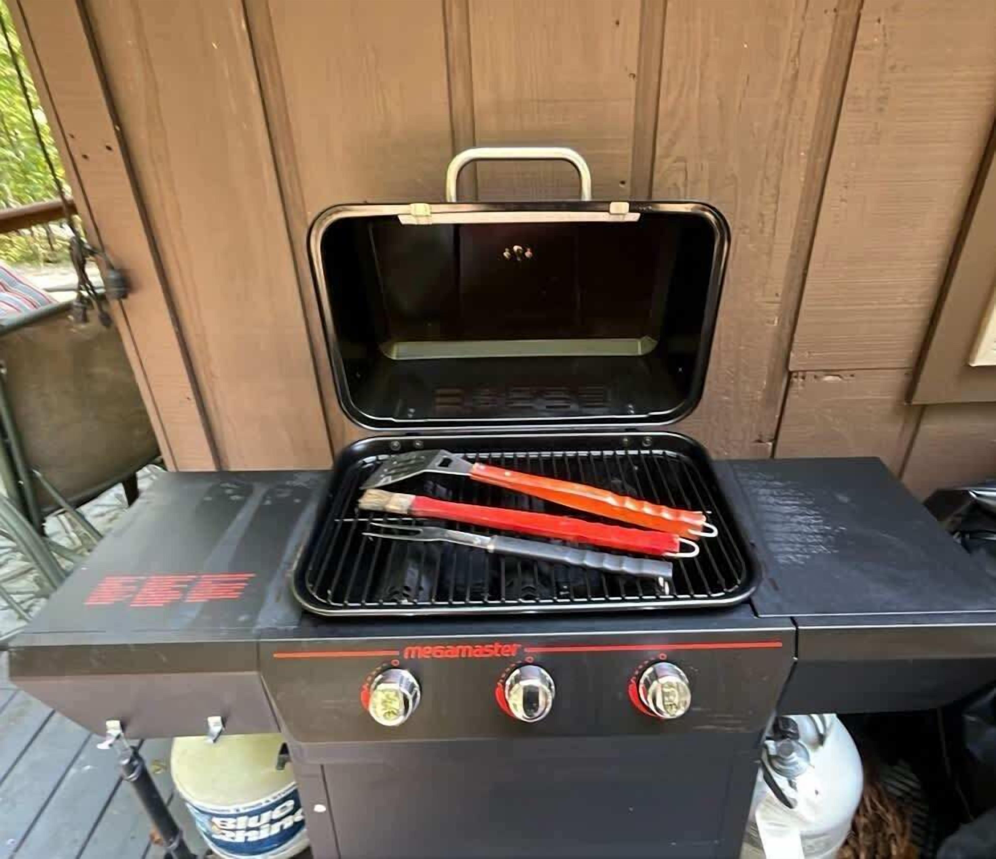 Un barbecue portable doté d’une poignée sur le dessus et de deux boutons de réglage.