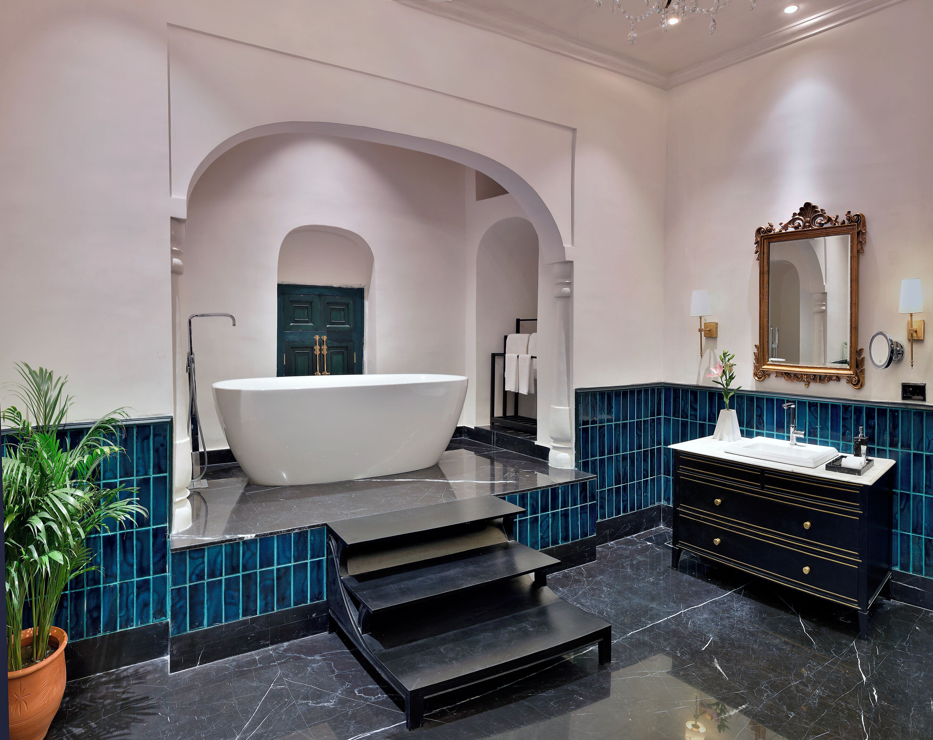 Une salle de bain moderne avec une baignoire sur pieds, un meuble-lavabo avec un miroir et une plante en pot.