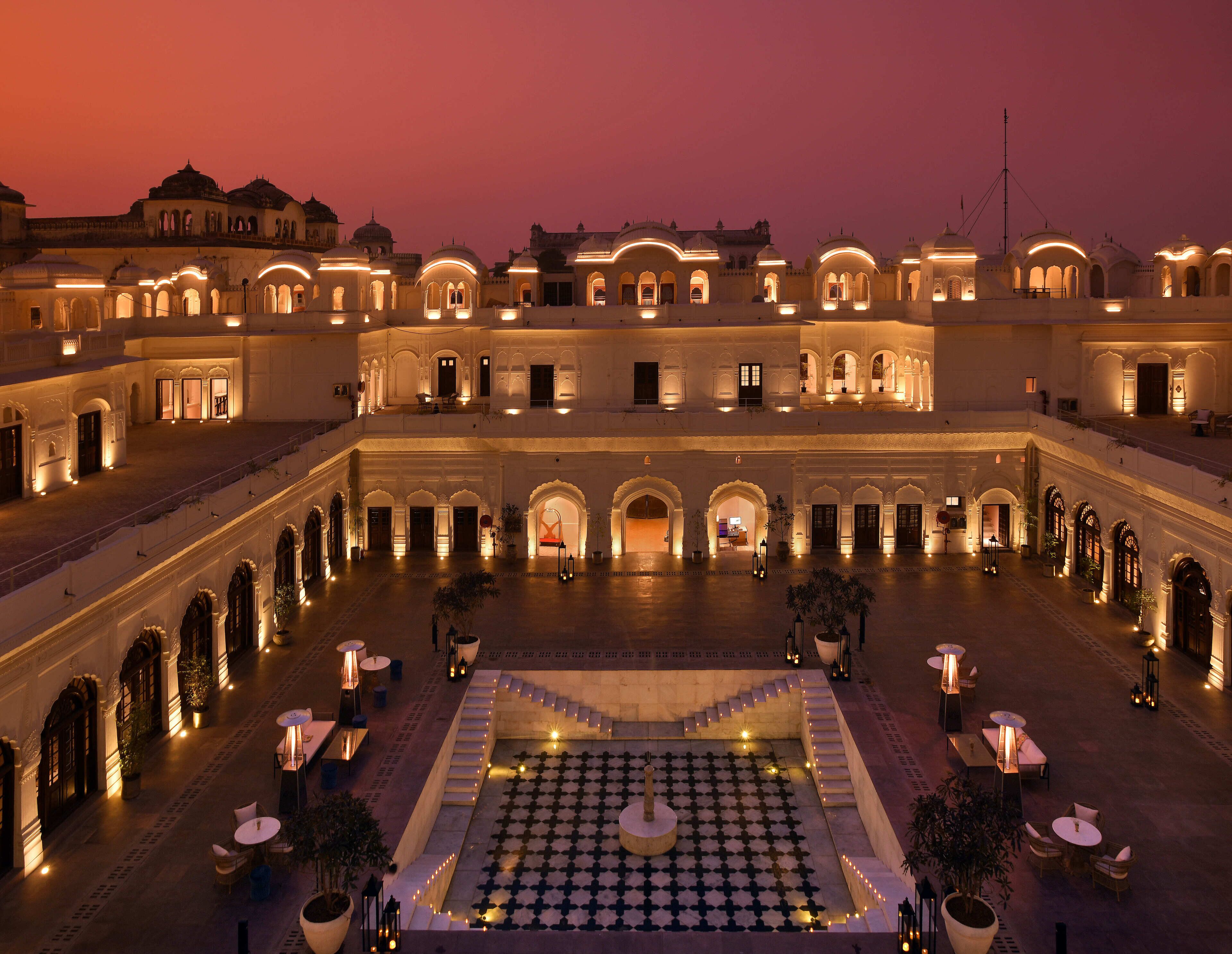 A courtyard with a central geometric pattern, surrounded by multiple levels of arched walkways and rooms.