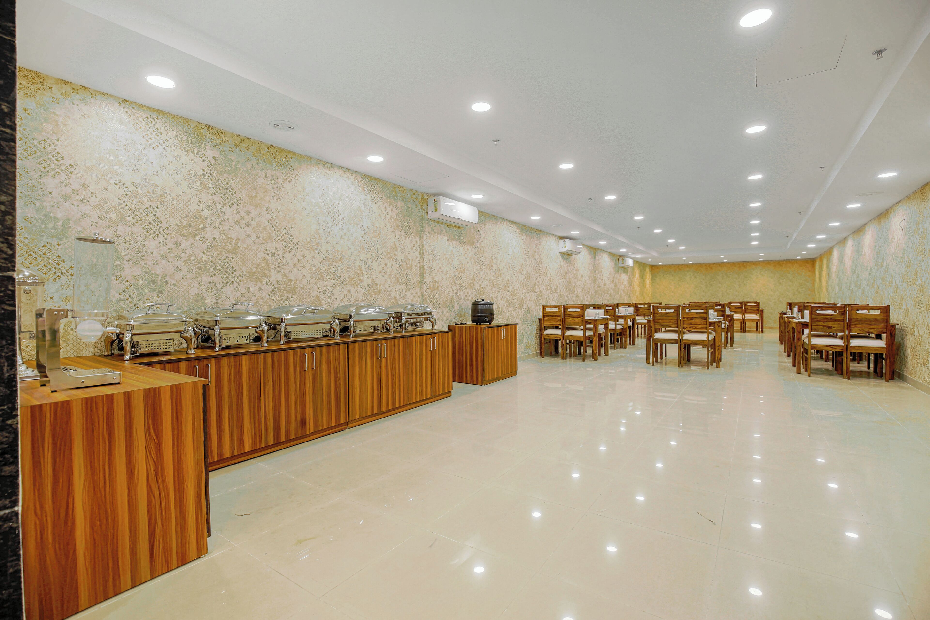 A spacious room with a long buffet counter, multiple chairs, and a tiled floor.