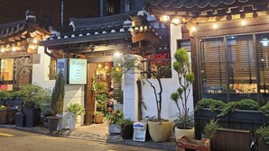 Un bâtiment de style japonais traditionnel, avec une enseigne indiquant « Patio », ce qui suggère qu’il s’agit d’un café ou d’un restaurant.
