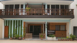 A two-story building with a balcony, potted plants, and a sign reading "Elysian Hideaway". - Elysian Hideaway Maafushi (Maafushi)