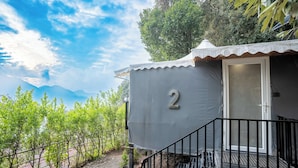 A small, single-story structure with a number '2' on its side, a door, and a staircase leading to a balcony. - The Whispering Oaks (Nainital)