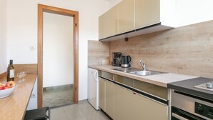 Une cuisine moderne dotée d’un plan de travail en bois, d’un four encastré et d’une machine à café.