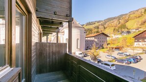 Un balcon donnant sur un parking et sur des bâtiments en arrière-plan.