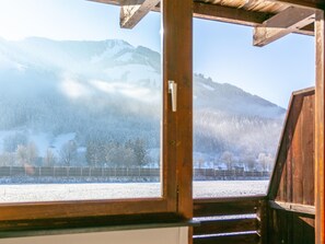 Escape to a serene mountain retreat with breathtaking views of snow-covered landscapes and a rustic wooden structure.