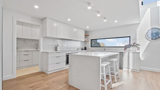 A modern kitchen with white cabinetry, a large island, and a view of the sky through a window. - Vista Heights  - Contemporary Entertainer (Kooringal)