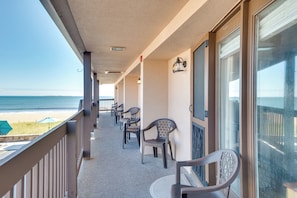 Ein Balkon mit Stühlen und Blick auf den Strand.