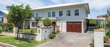 A two-story house with a garage, a driveway, and a well-maintained lawn.