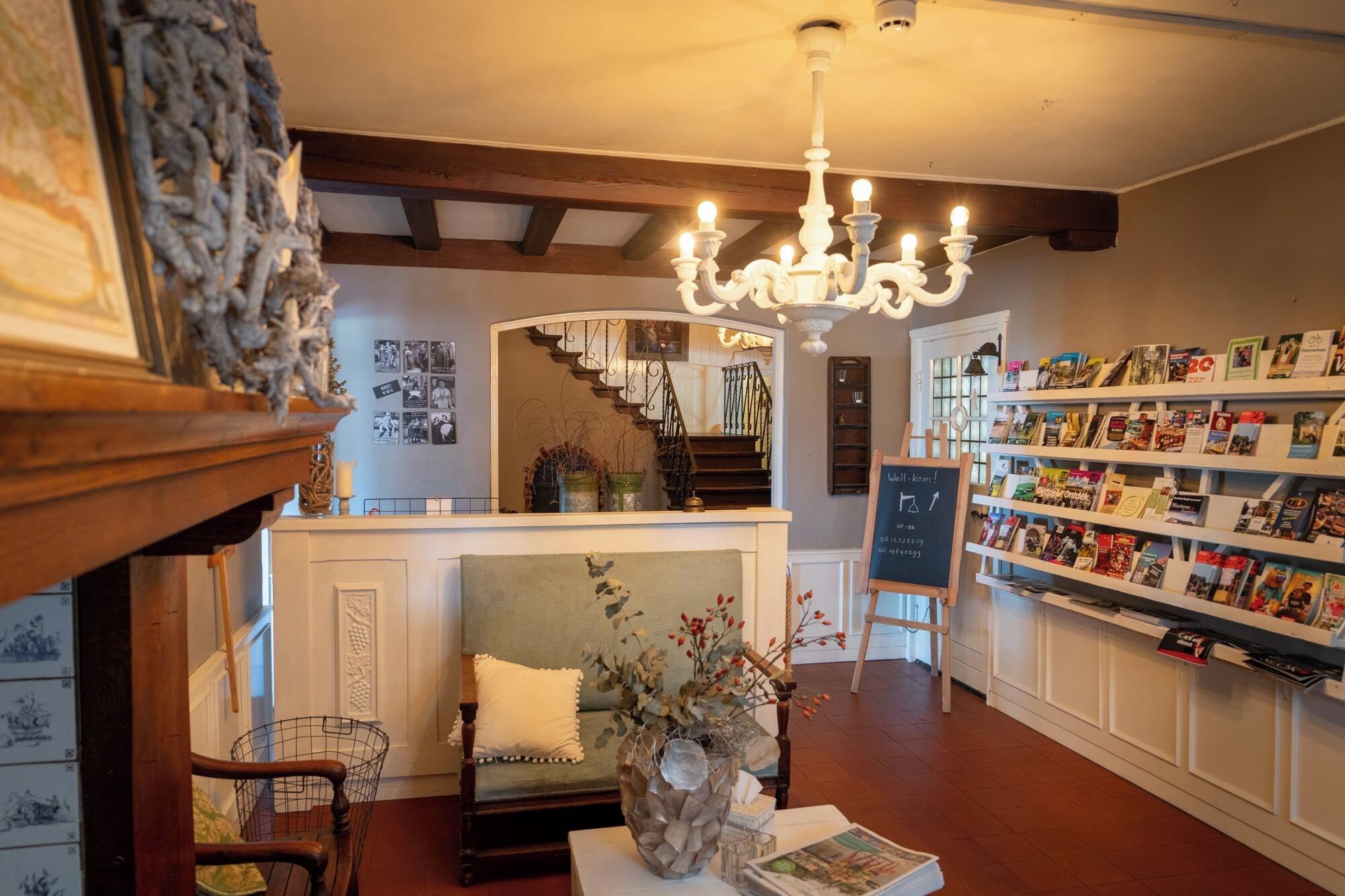 Una librería acogedora con una escalera de madera, un candelabro y una gran variedad de estanterías.