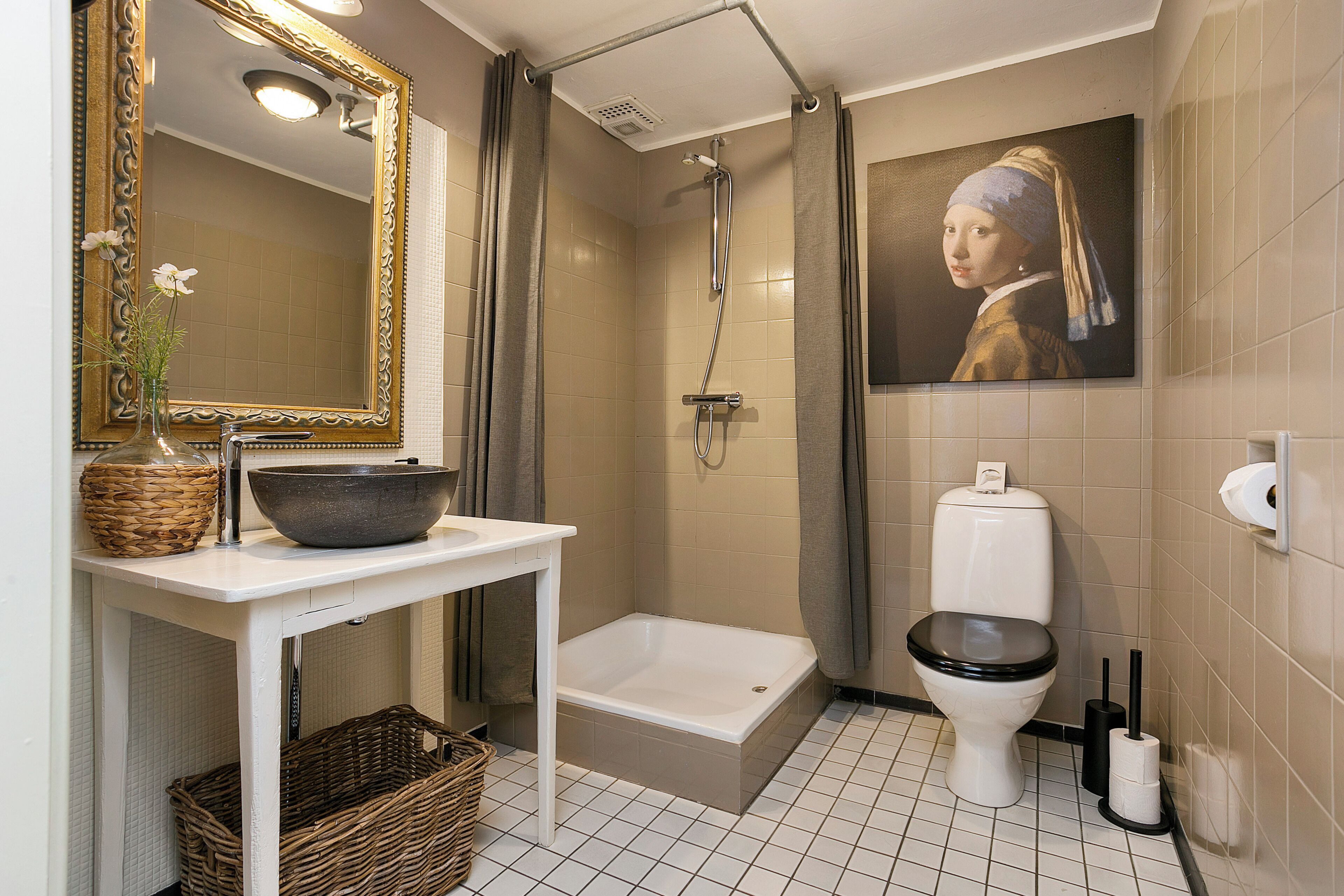 Een badkamer met een badkuip, toilet en een grote spiegel.