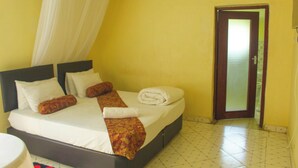 A hotel room with a bed, a curtain, a door, and a tiled floor. - mirok gardens kisumu (Kisumu)