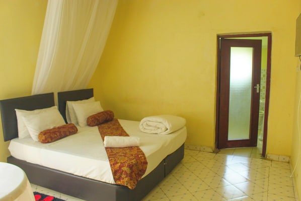 A hotel room with a bed, a curtain, a door, and a tiled floor. - mirok gardens kisumu (Kisumu)