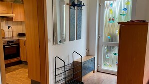 A kitchen with wooden cabinets, a stove, and a window with decorative stickers. - Holiday Apartment Ingrid Rautenberg with Private Terrace, Garden and Wi-Fi (Krautheim)