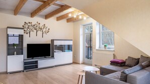 Una sala de estar moderna con televisor de pantalla plana, mueble empotrado de entretenimiento y una zona de estar acogedora.