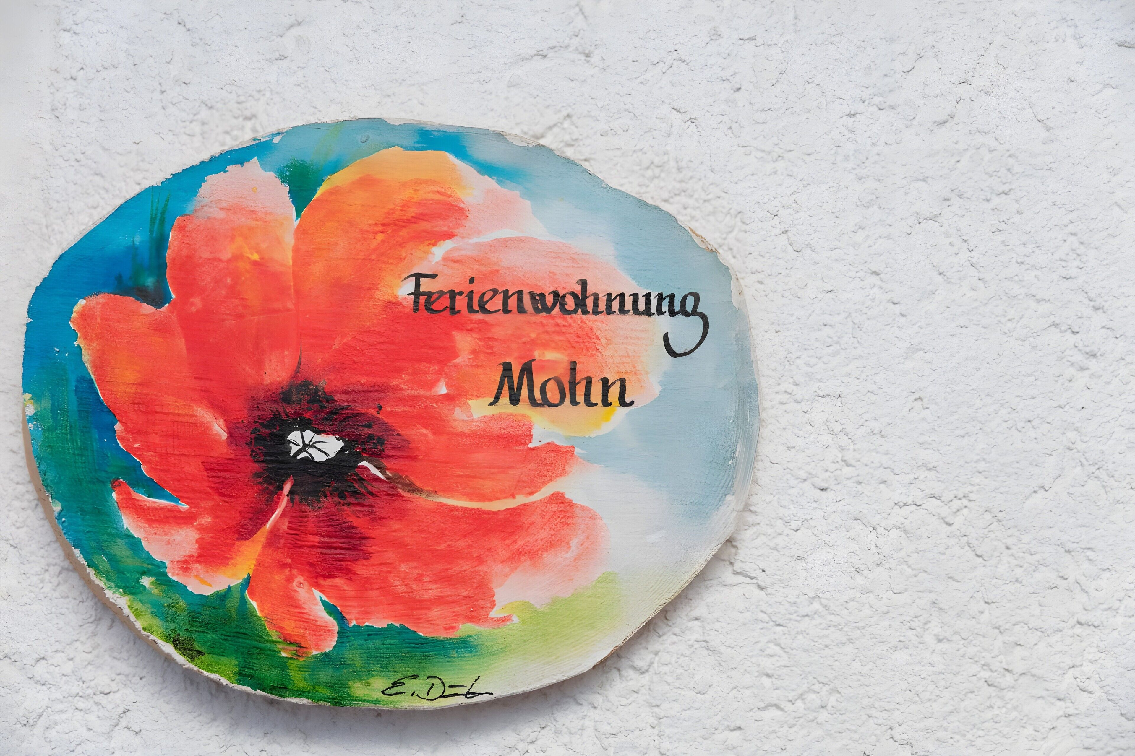 Een rond, plat voorwerp met een kleurrijk bloemendesign en de tekst 'Ferienwohnung München'.