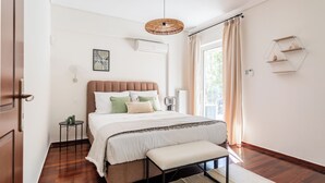 Un dormitorio con cama, mesita de noche y lámpara colgante.