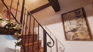 Una scala con ringhiere in metallo decorate e un elemento decorativo a parete raffigurante uccelli e farfalle.
