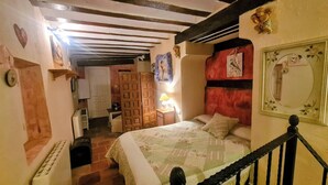 Una camera da letto con un letto, un comodino, una lampada, uno specchio e un armadio.