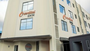 Ein Hotel mit der Beschilderung 'Charli's Inn', einer schlichten Fassade und einem einfachen Eingang mit Topfpflanzen.