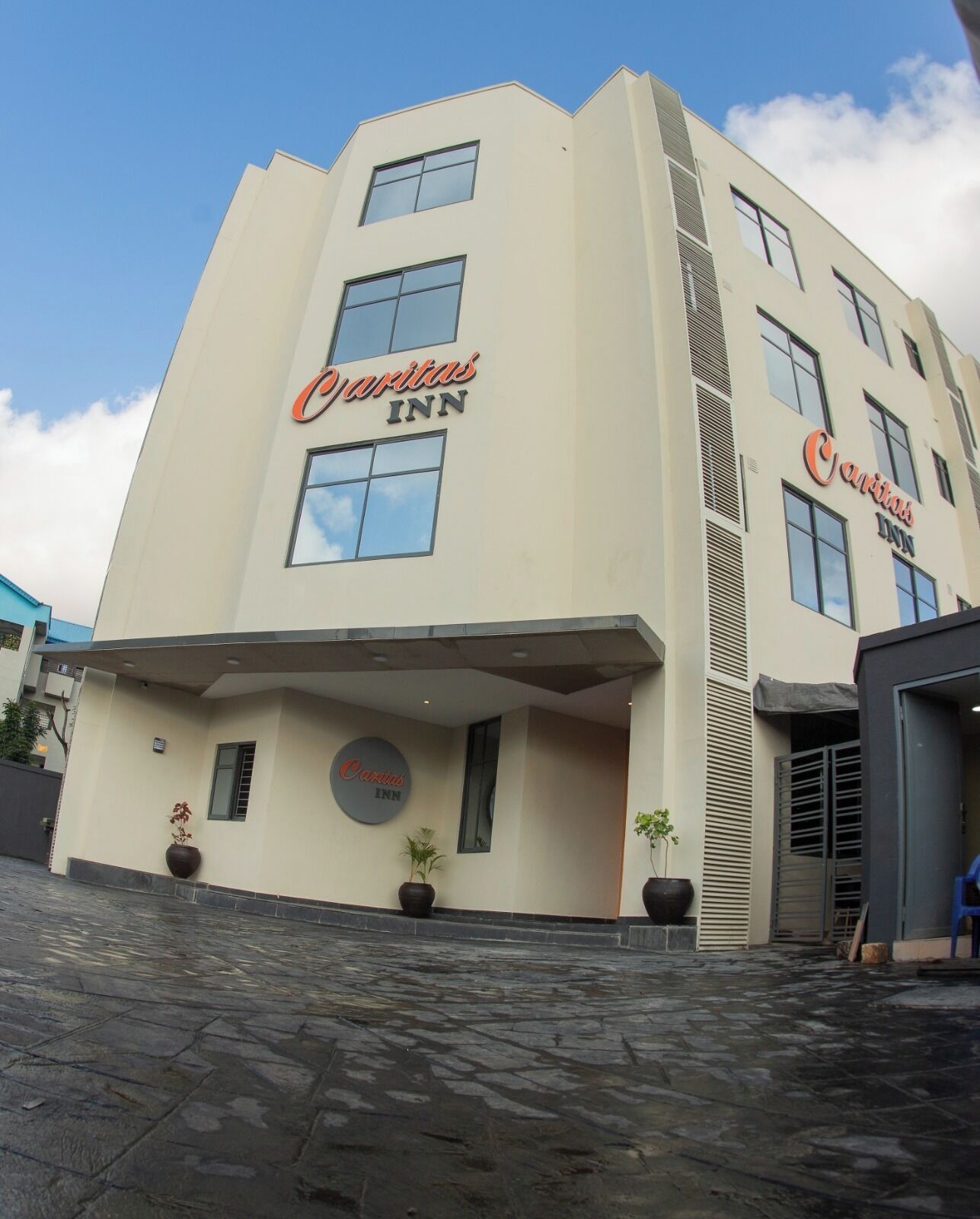 A building with the sign 'Caritas Inn' indicating it is a hotel.