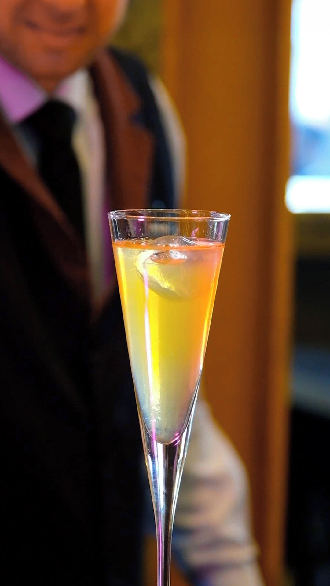 Un cóctel en una copa de martini con un fondo desenfocado.
