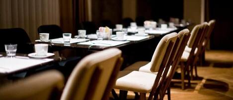 A conference room with a long table, chairs, and water glasses.