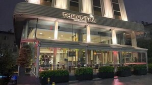 A modern hotel with a prominent vertical design, large glass windows, and a well-lit entrance. - The Cettia İstanbul (Istanbul)