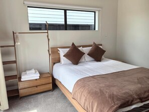 A bedroom with a bed, pillows, a wooden ladder, and a window. - Hideaway in Green Hill Park (Hamilton)