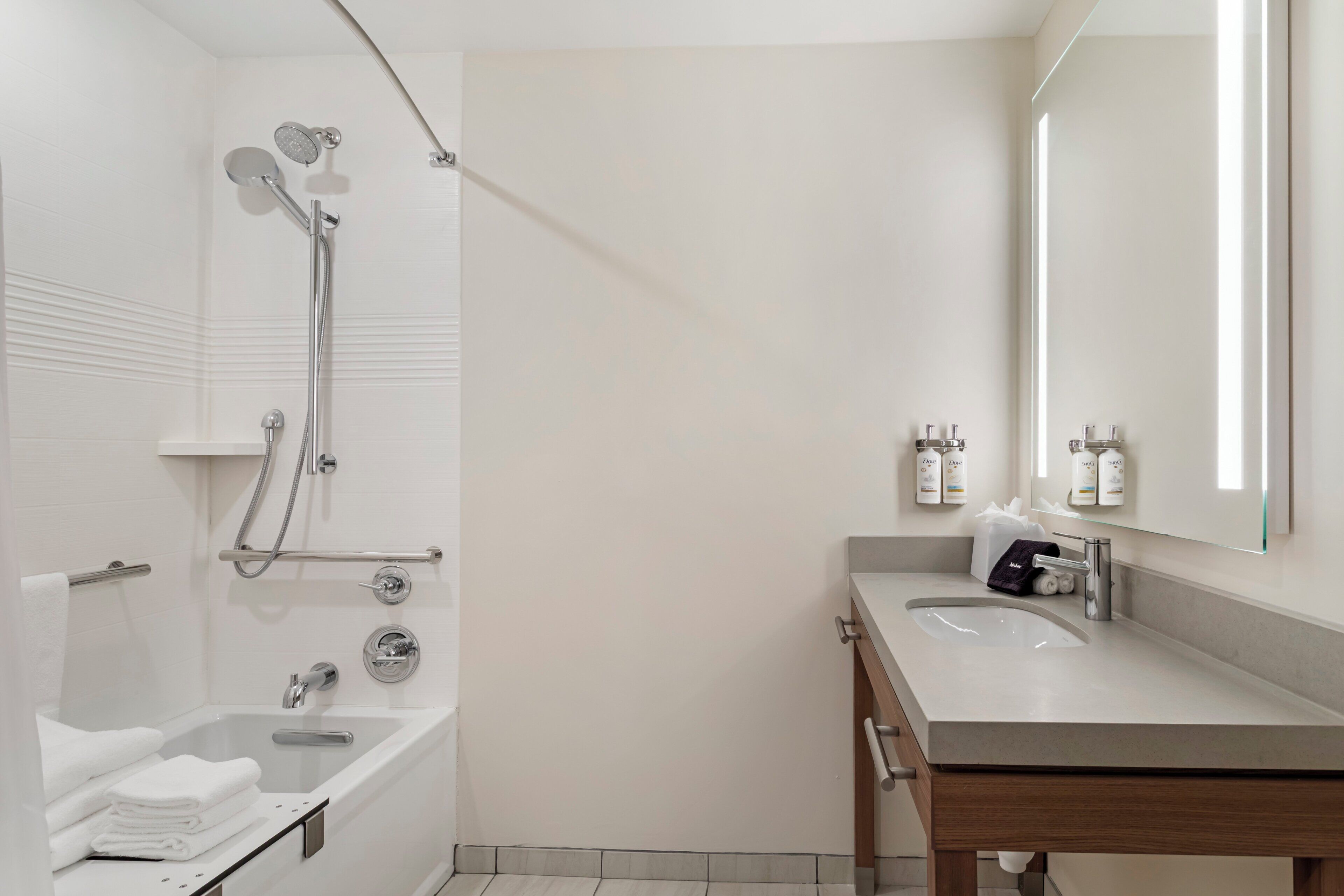 A modern bathroom with a bathtub, a shower, and a vanity with a mirror.
