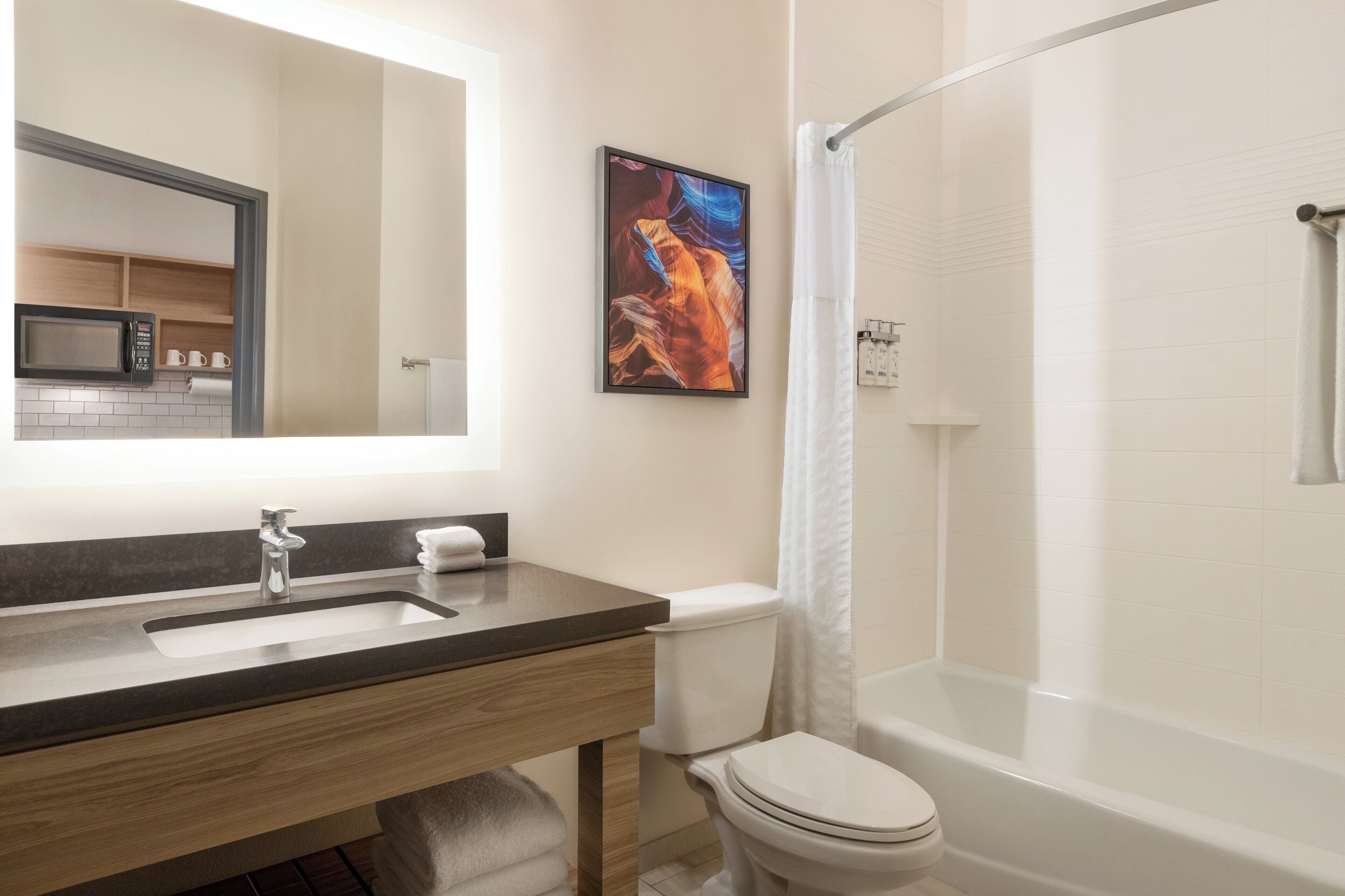 Une salle de bain moderne équipée d’un lavabo, de toilettes et d’une douche.