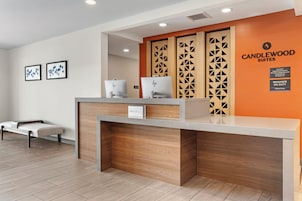 A hotel reception desk with a modern design, a sign indicating the hotel name, and a manager on duty sign.