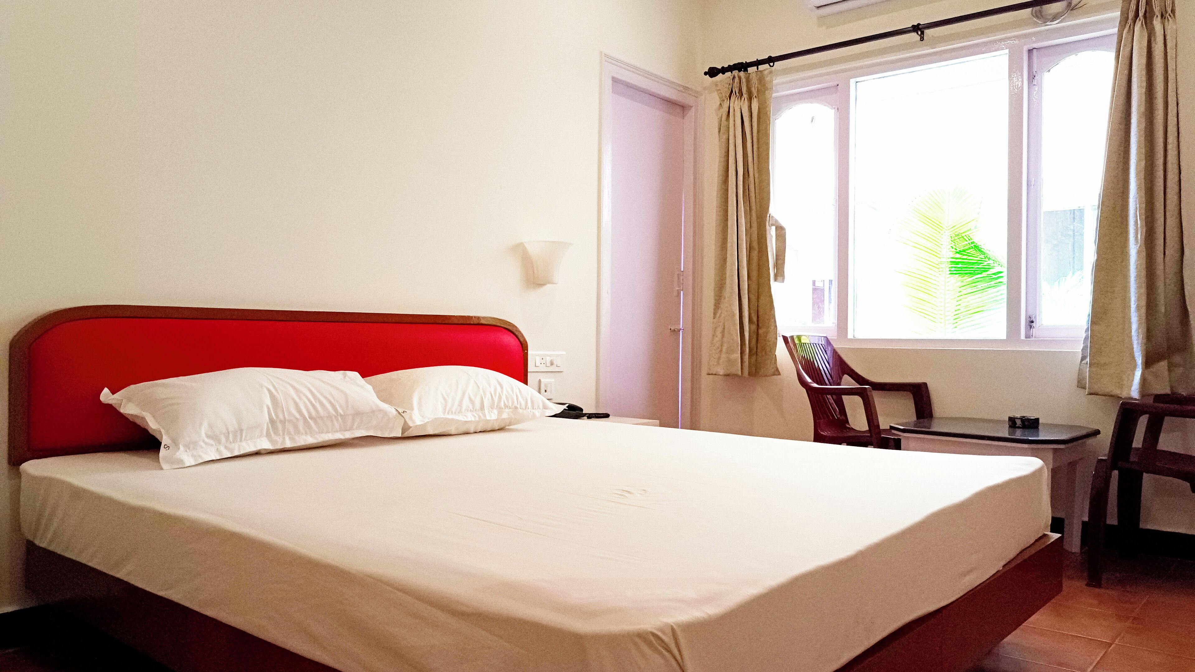 Una habitación de hotel con una cama individual, una mesita y una silla.