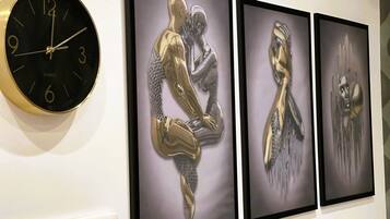 A wall clock and three framed artworks.