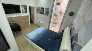 Una camera da letto con un letto, una scrivania e una televisione.